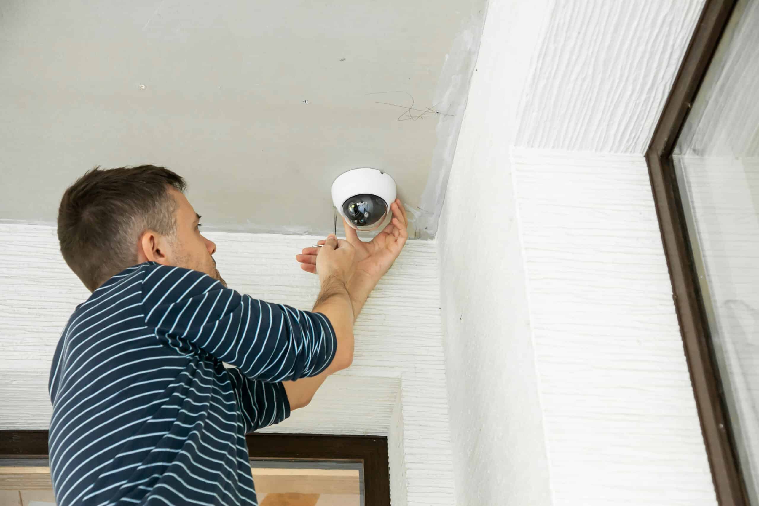 Man installs security camera in private house under construction Security system